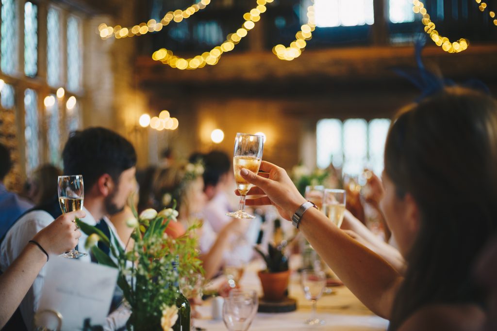 Salle de fête avec invités qui lèvent leur coupe de champagne