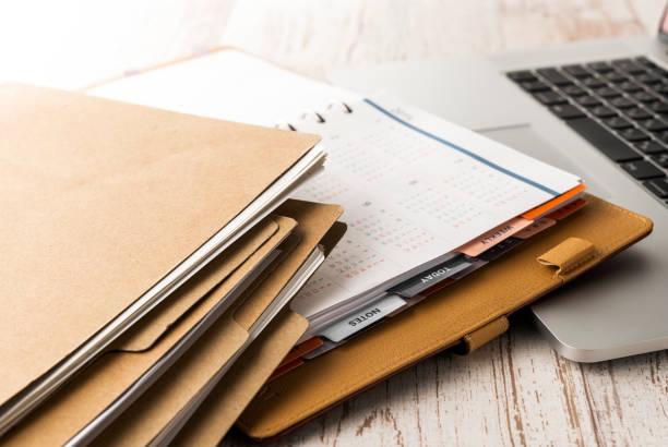 Pile de dossiers et ordinateur portable sur un bureau