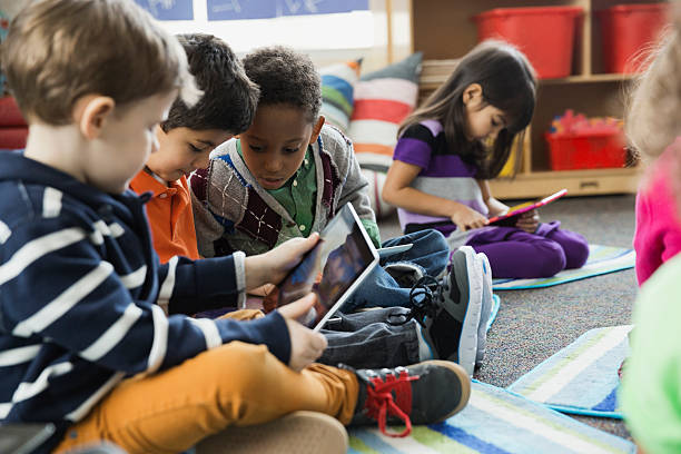 Enfants en maternelle sur des tablettes numériques