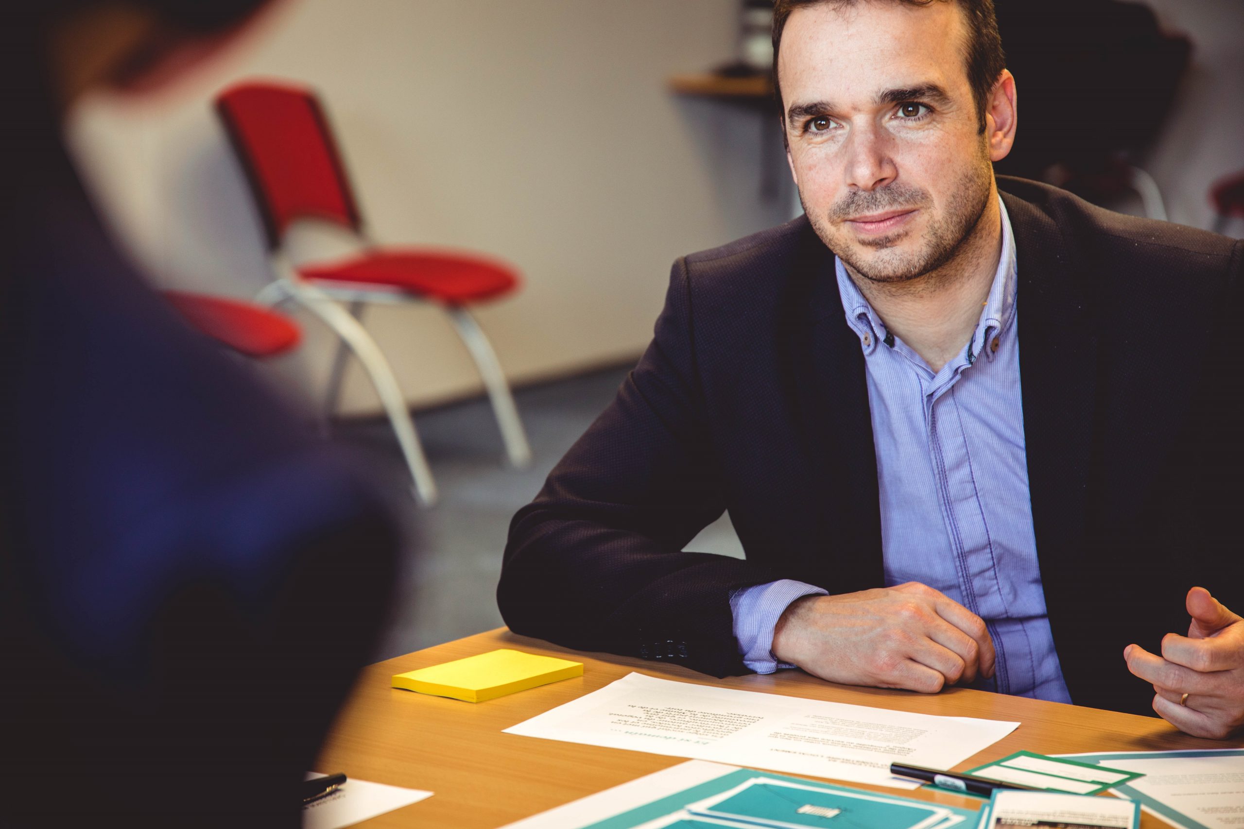 homme assis derrière un bureau avec des documents sur le bureau